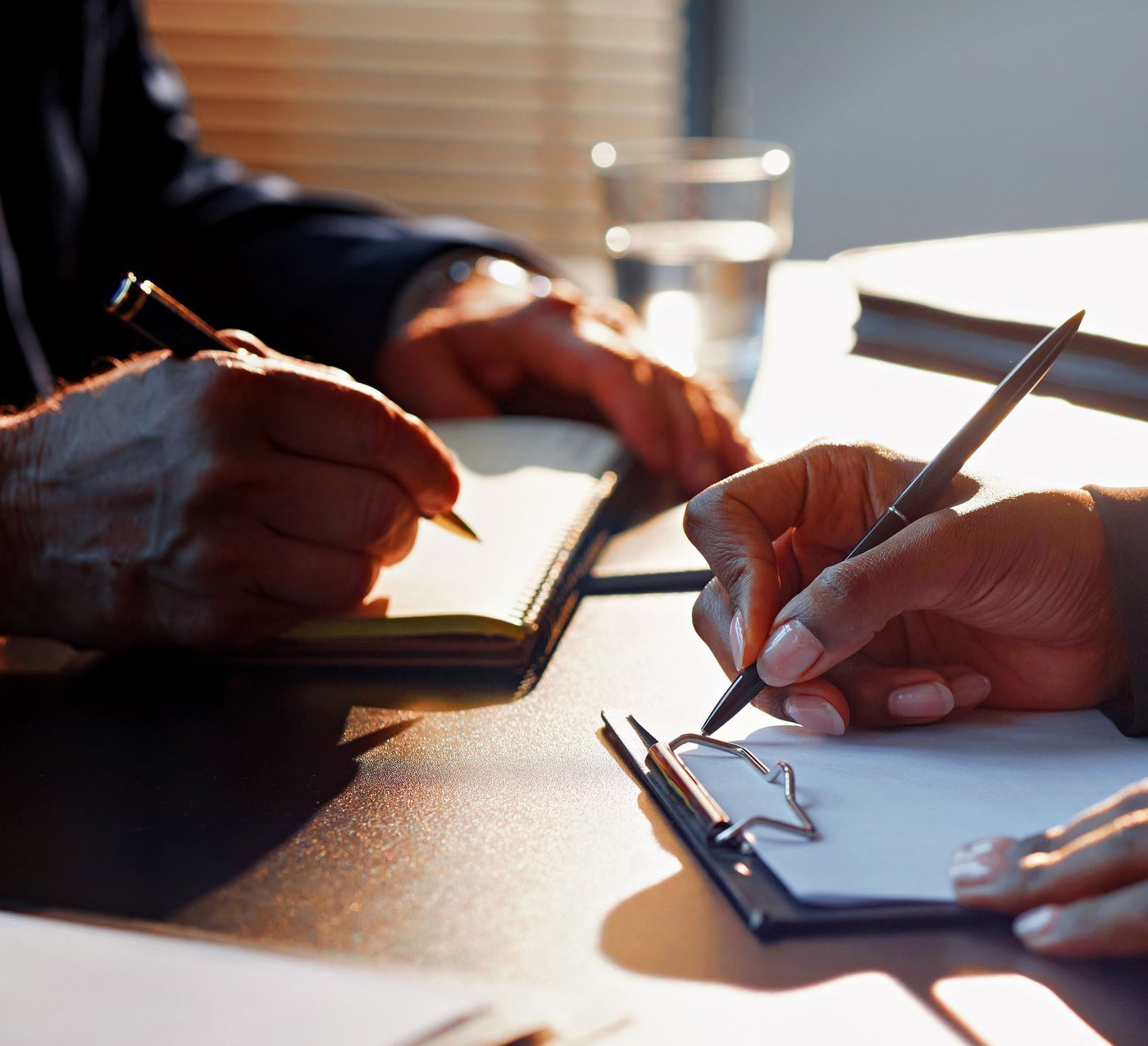 Two people signing contract documents at a desk