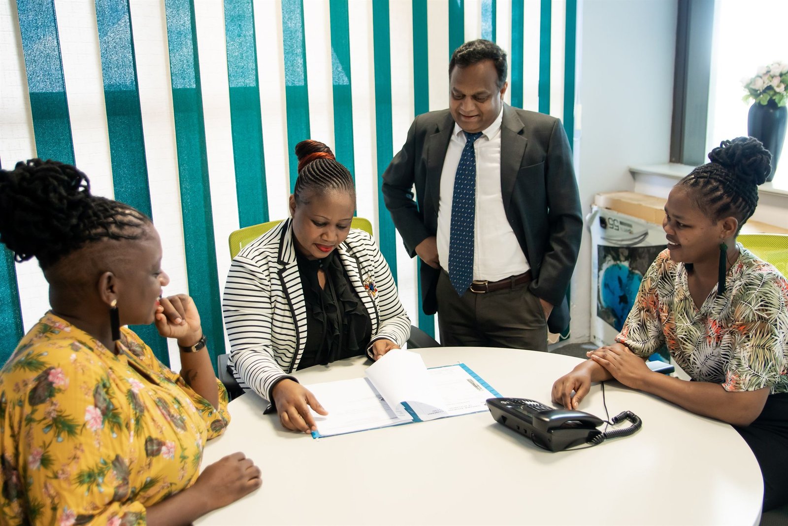 The Sunshine Insurance team reviewing a policy file at the Gaborone office